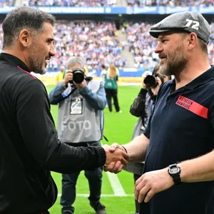 Cristian Fiél und Steffen Baumgart gebrüßen sich per Handschlag im Volksparkstadion