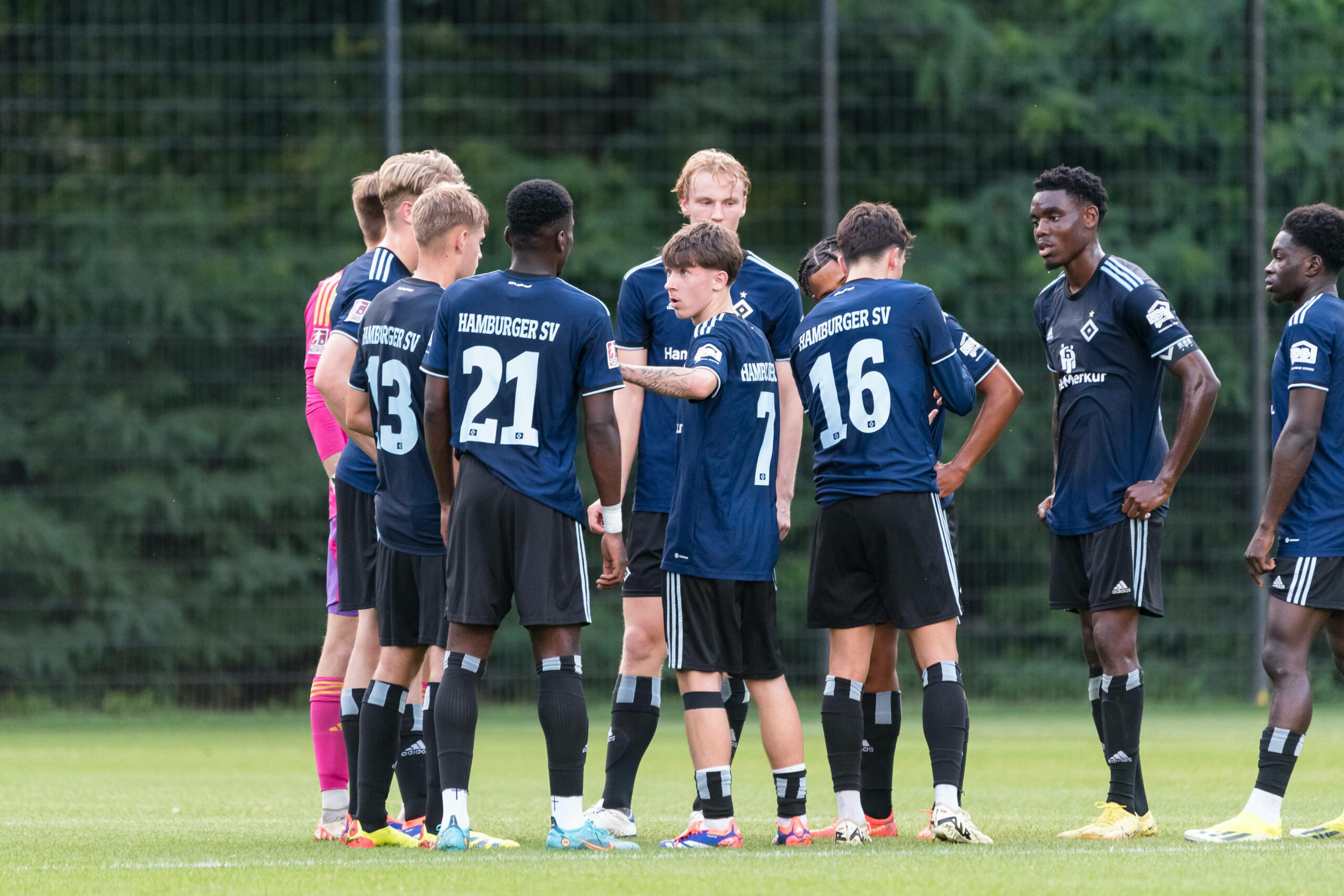 Die Talente der HSV-U21 stehen auf dem Spielfeld im Kreis und beraten sich