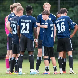 Die Talente der HSV-U21 stehen auf dem Spielfeld im Kreis und beraten sich
