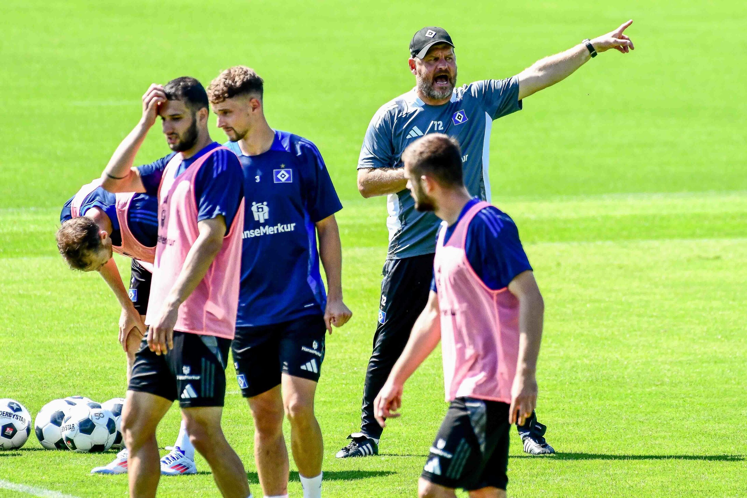 HSV-Trainer Steffen Baumgart streckt im Training neben Moritz Heyer und Levin Öztunali einen Finger in die Höhe