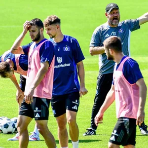 HSV-Trainer Steffen Baumgart streckt im Training neben Moritz Heyer und Levin Öztunali einen Finger in die Höhe