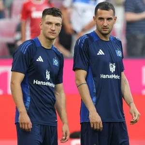 Noah Katterbach und Levin Öztunali schauen beim Aufwärmen in Köln über den Platz