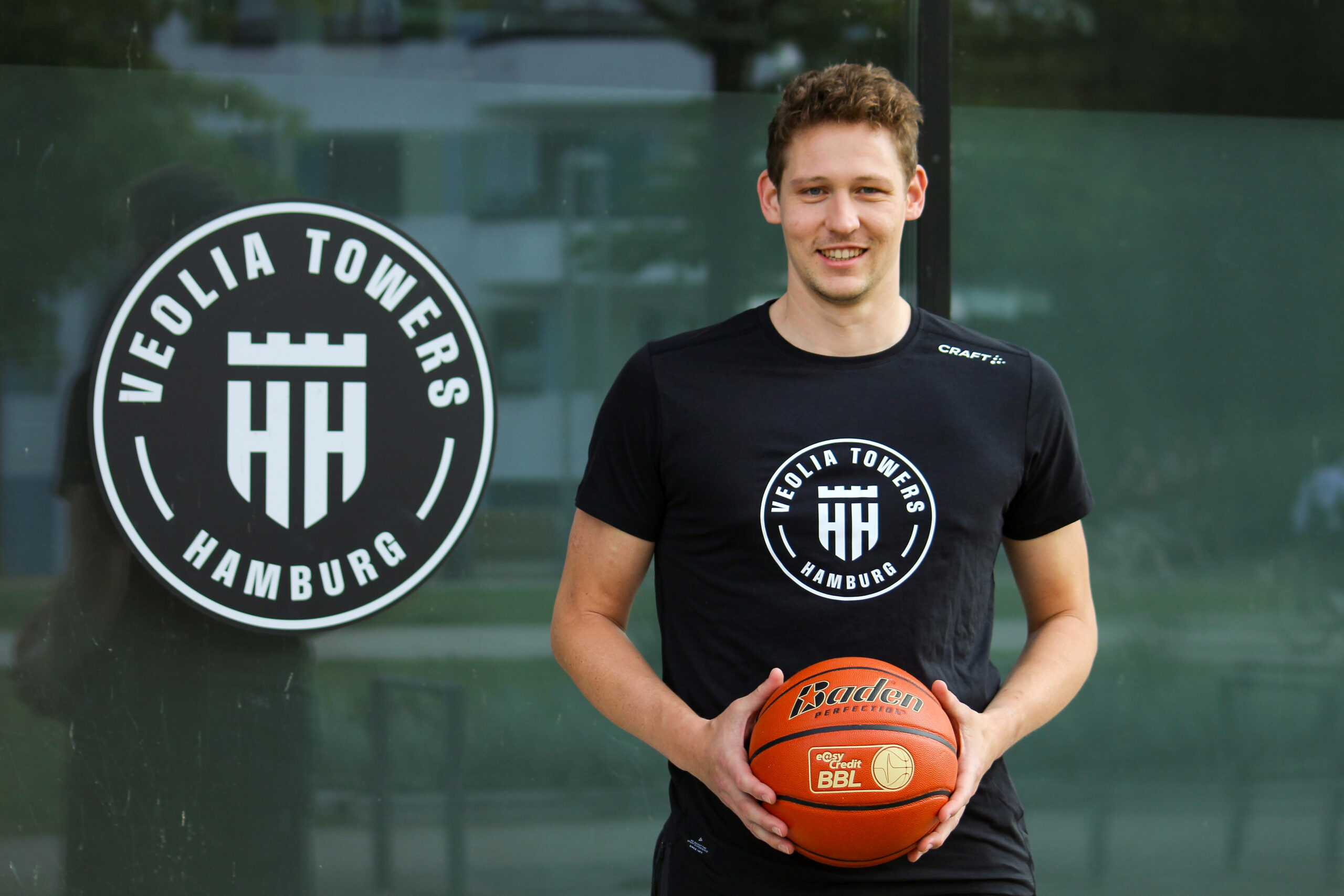 Patrick Heckmann mit dem Basketball in der Hand vor dem Inselpark.