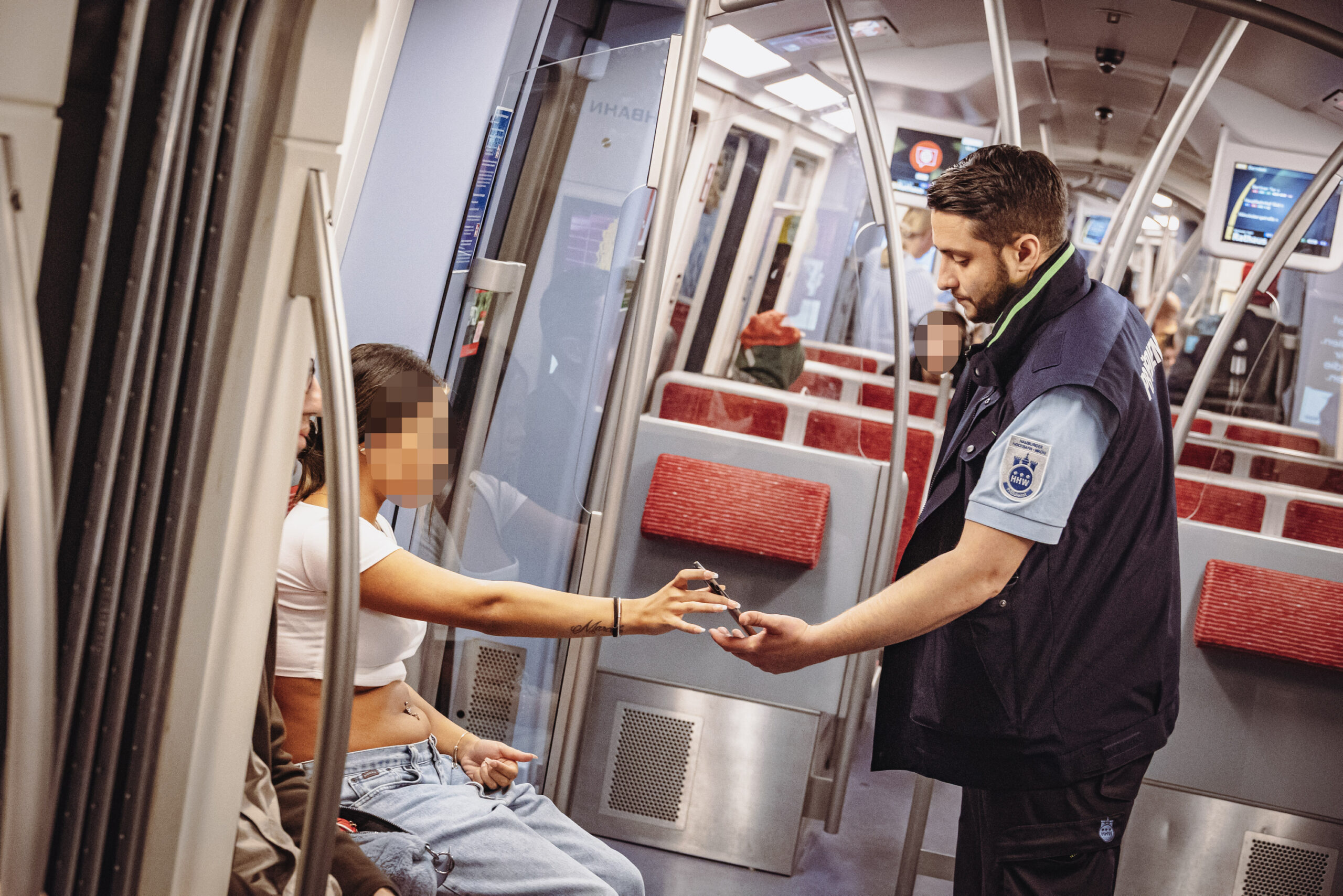 Ein Mitarbeiter der Hochbahnwache kontrolliert einen Fahrgast in der U-Bahn.