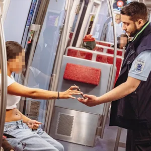 Ein Mitarbeiter der Hochbahnwache kontrolliert einen Fahrgast in der U-Bahn.