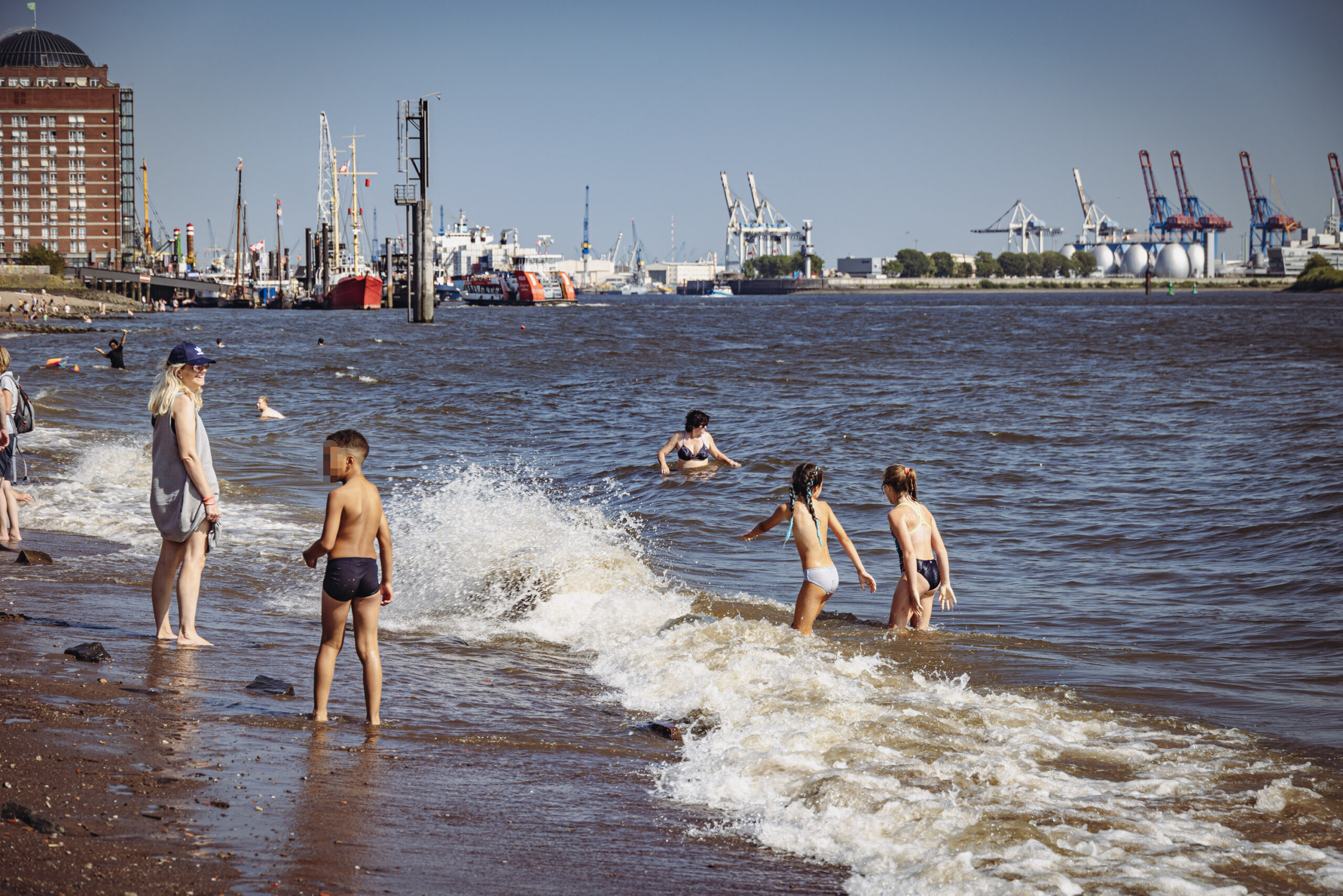 Bei gutem Wetter baden viele Menschen in der Elbe, darunter auch einige Kinder.