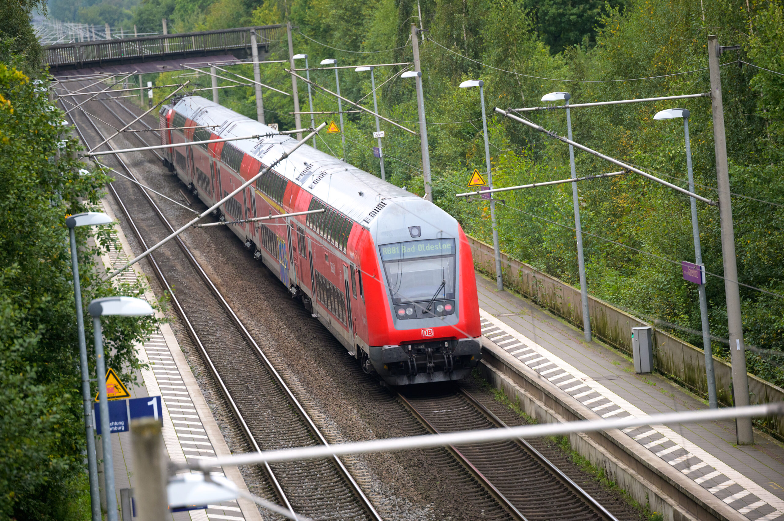 Ein doppelstöckiger Regionalzug der Deutschen Bahn fährt durch einen Bahnhof.