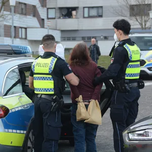 Mord in Lohbrügge, Röpraredder. Eine Frau wird von Polizeibeamten abgeführt.