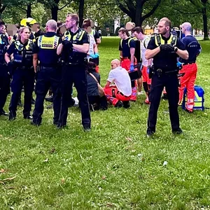 Polizisten schirmen Rettungssanitäter ab, die neben dem Palästina-Camp auf der Moorweide eine Person versorgen.