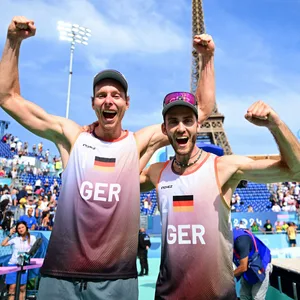 Die Beachvolleyballer Nils Ehlers und Clemens Wickler jubeln nach ihrem Sieg im Achtelfinale