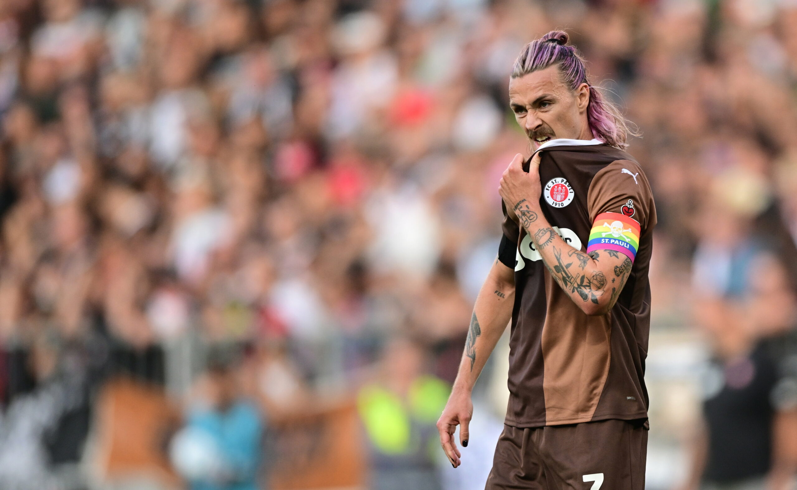 Jackson Irvine zieht sich sein St. Pauli-Trikot übers Kinn.