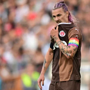 Jackson Irvine zieht sich sein St. Pauli-Trikot übers Kinn.