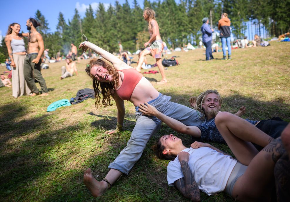 Mitglieder der Rainbow Family tanzen ausgelassen in ihrem Zeltlager im Harz.