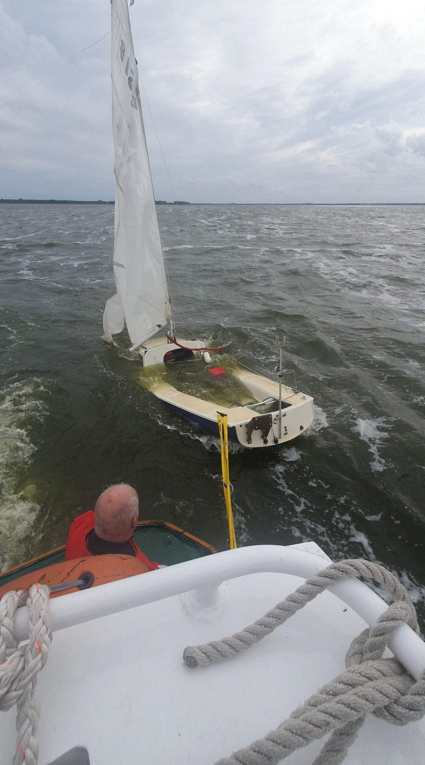 Mit dem Seenotrettungsboot „Hecht“ schleppen die freiwilligen Seenotretter aus Zinnowitz das etwa fünf Meter lange Segelboot nach Netzelkow.