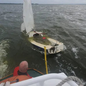 Mit dem Seenotrettungsboot „Hecht“ schleppen die freiwilligen Seenotretter aus Zinnowitz das etwa fünf Meter lange Segelboot nach Netzelkow.