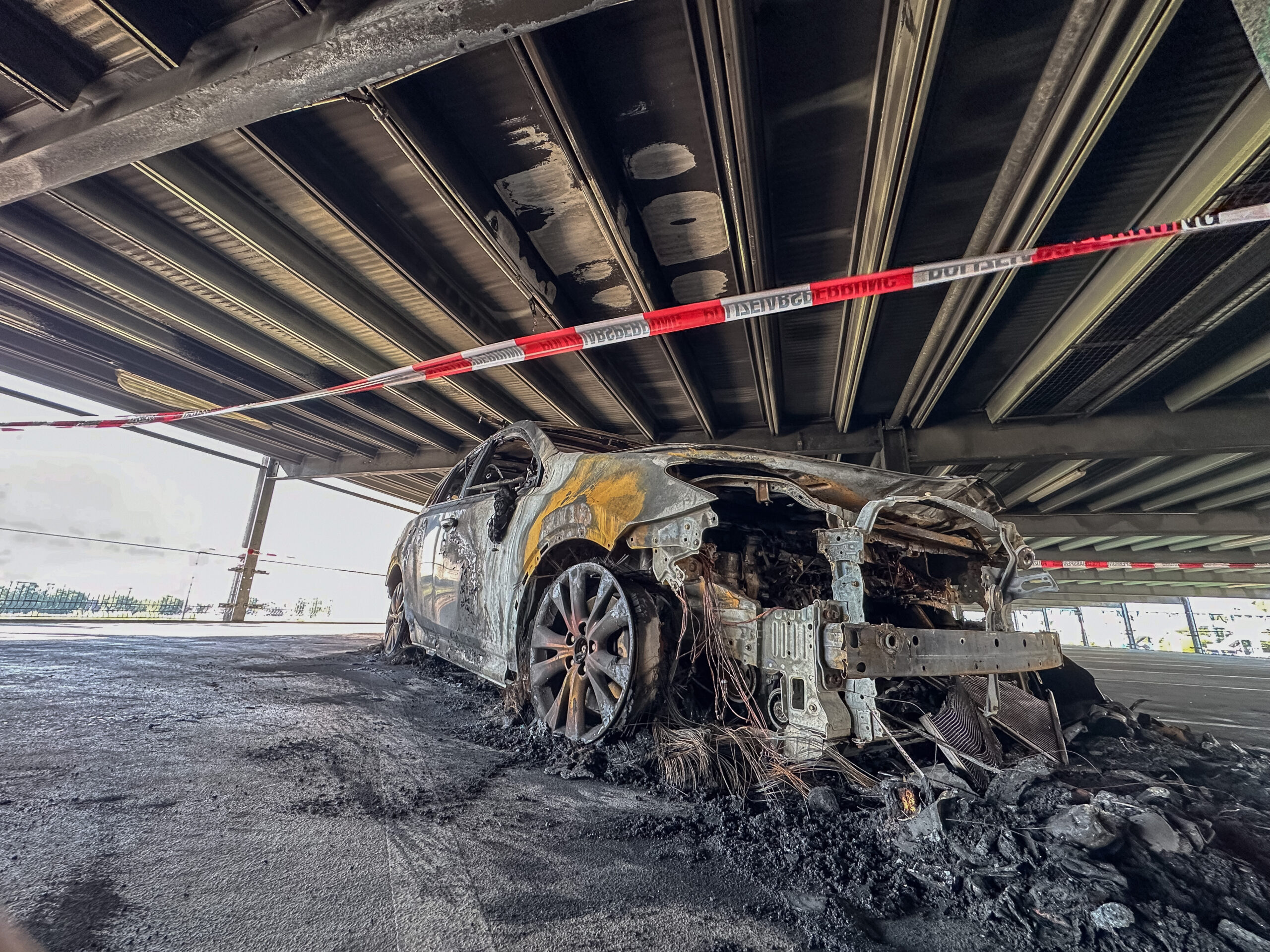 Ausgebranntes Autowrack in einem Parkhaus