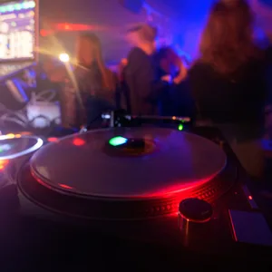 Partygänger tanzen vor einem DJ-Pult in einem Club im Schanzenviertel.
