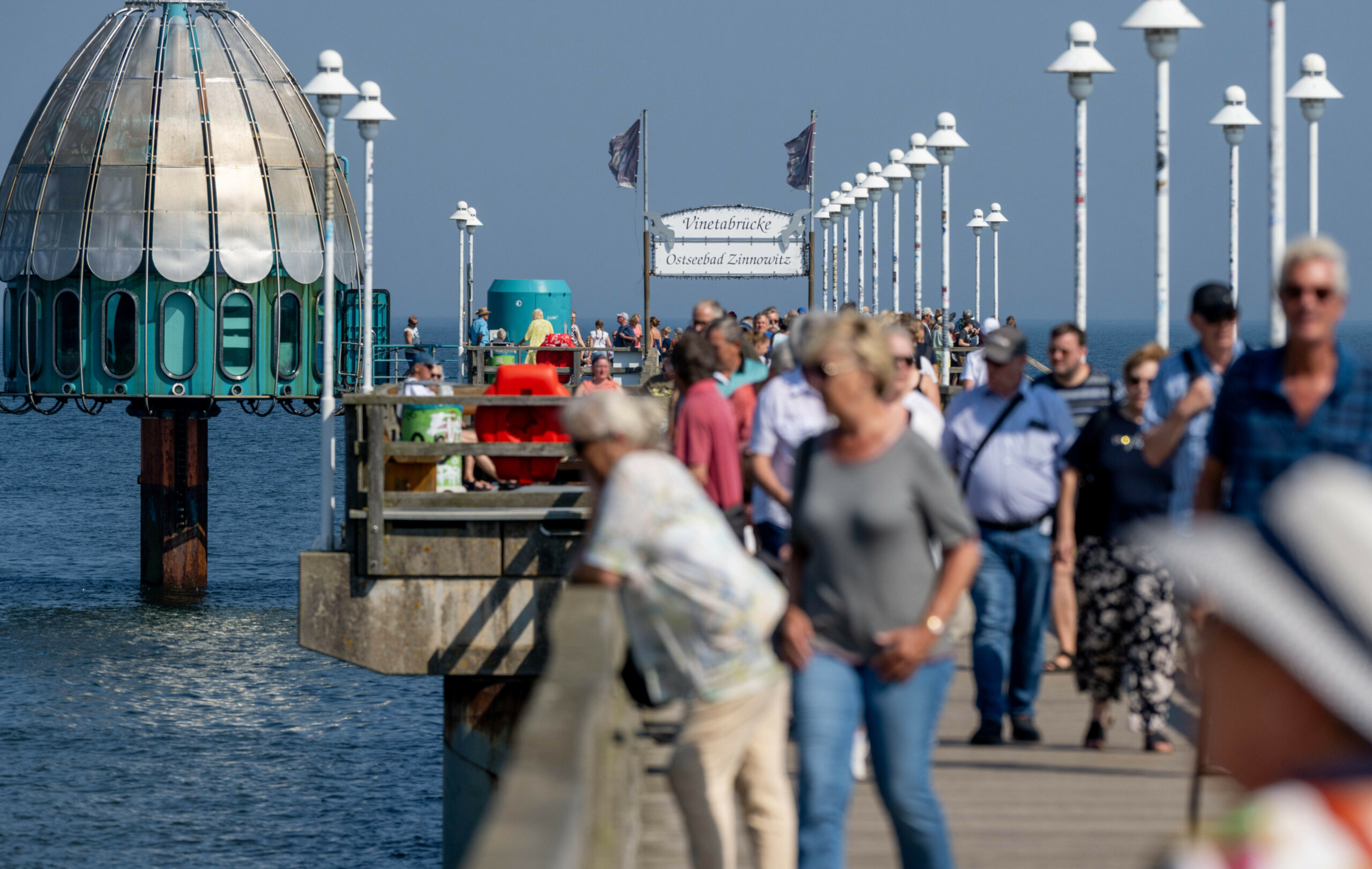 Auf der Seebrücke vom Ostseebad Zinnowitz sind Spaziergänger unterwegs.