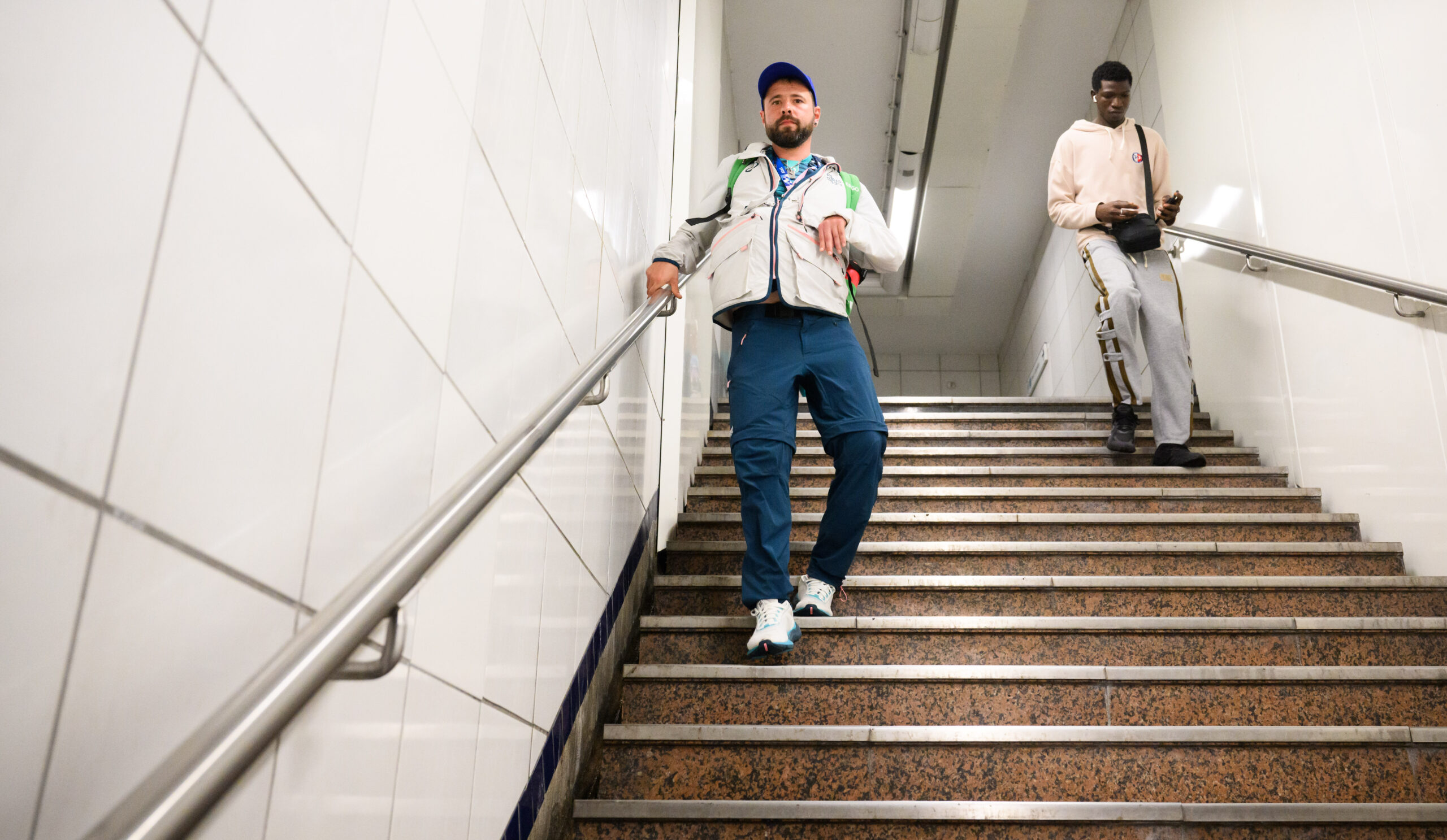 Ein Paralympics-Volunteer geht in Paris eine Treppe zur Metro hinunter