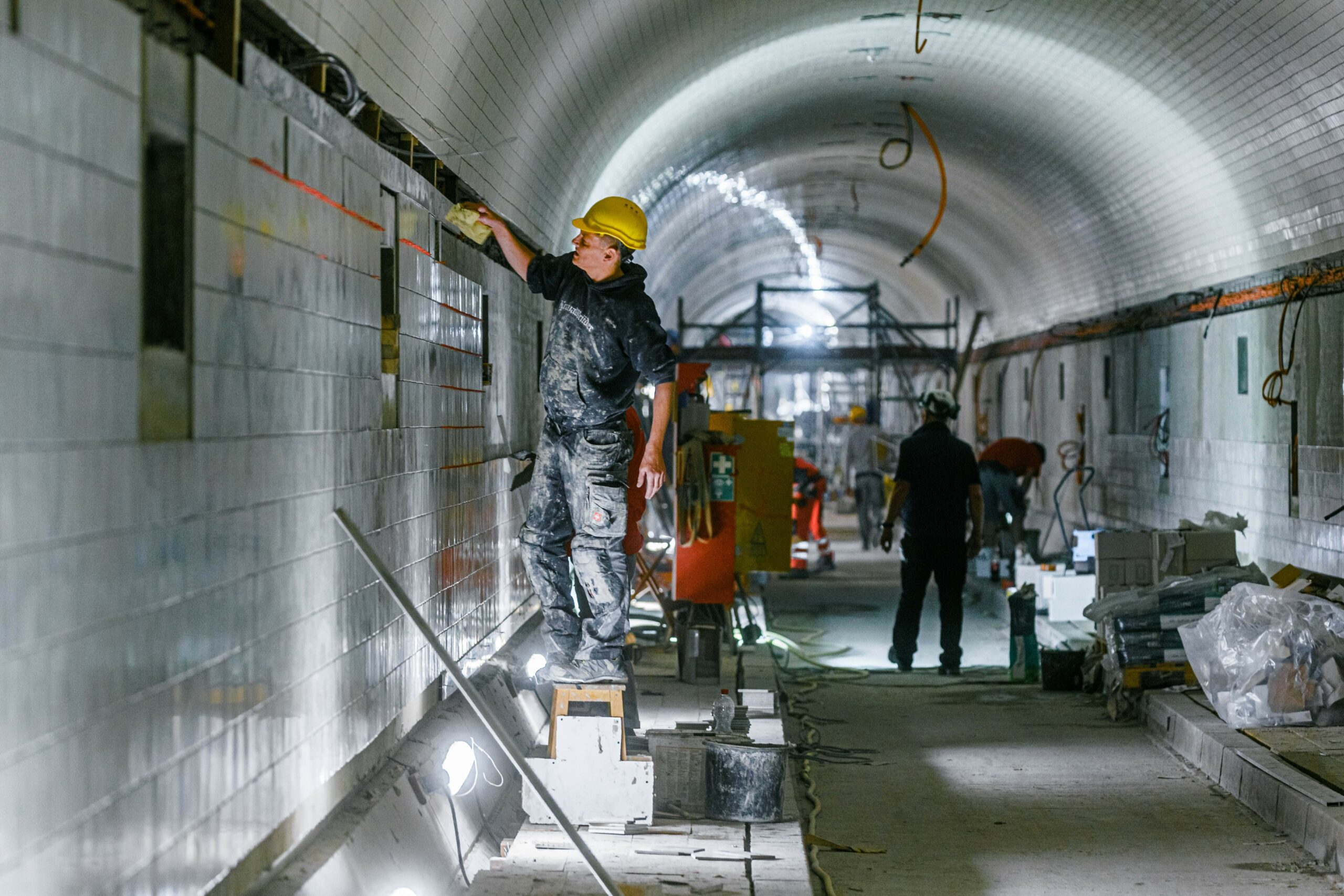 Arbeiter kacheln die Wände der Weströhre des St.Pauli Elbtunnels.