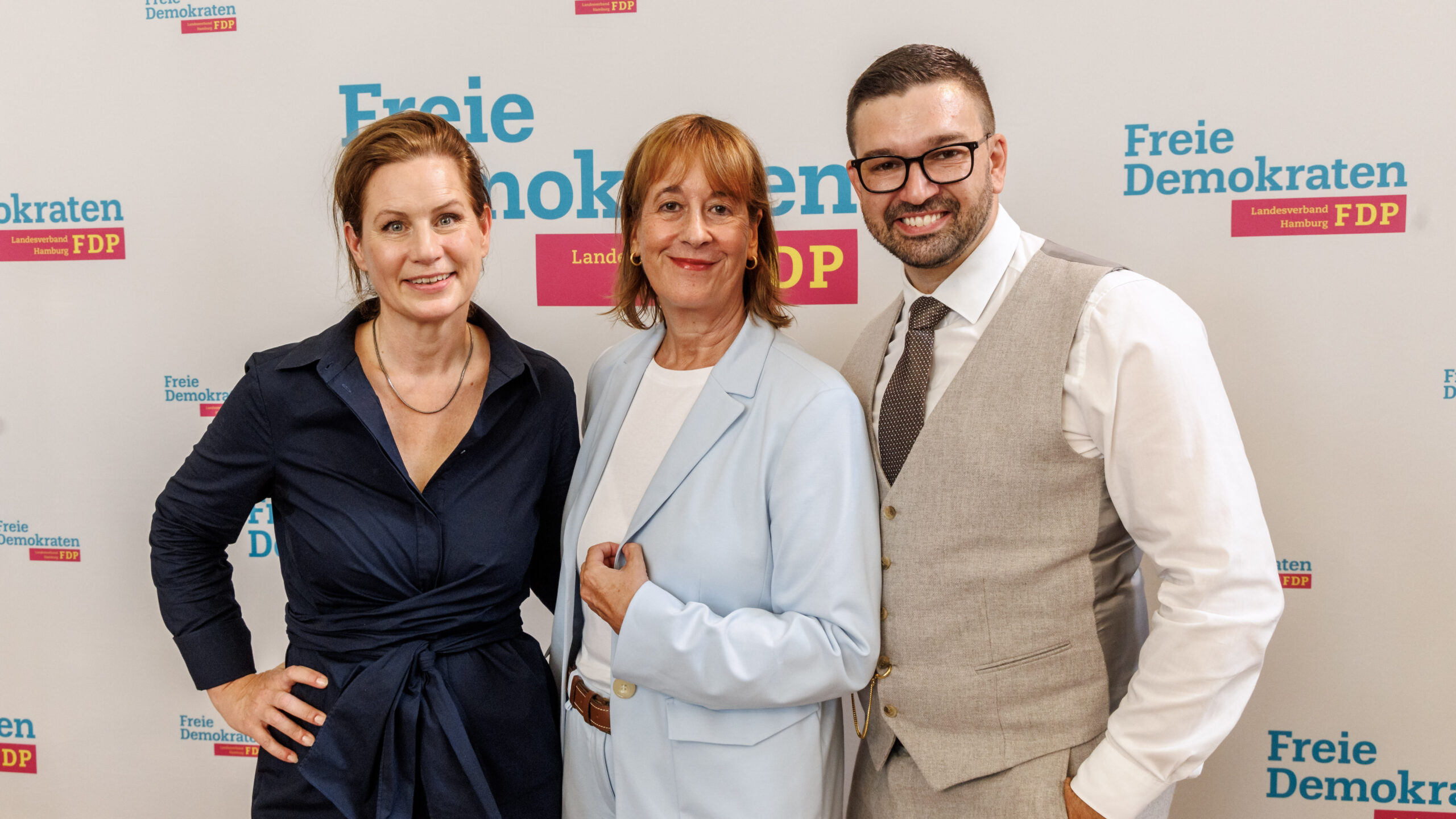 Sonja Jacobsen, Katarina Blume und Sami Musa stehen auf der Mitgliederversammlung der FDP Hamburg zusammen.