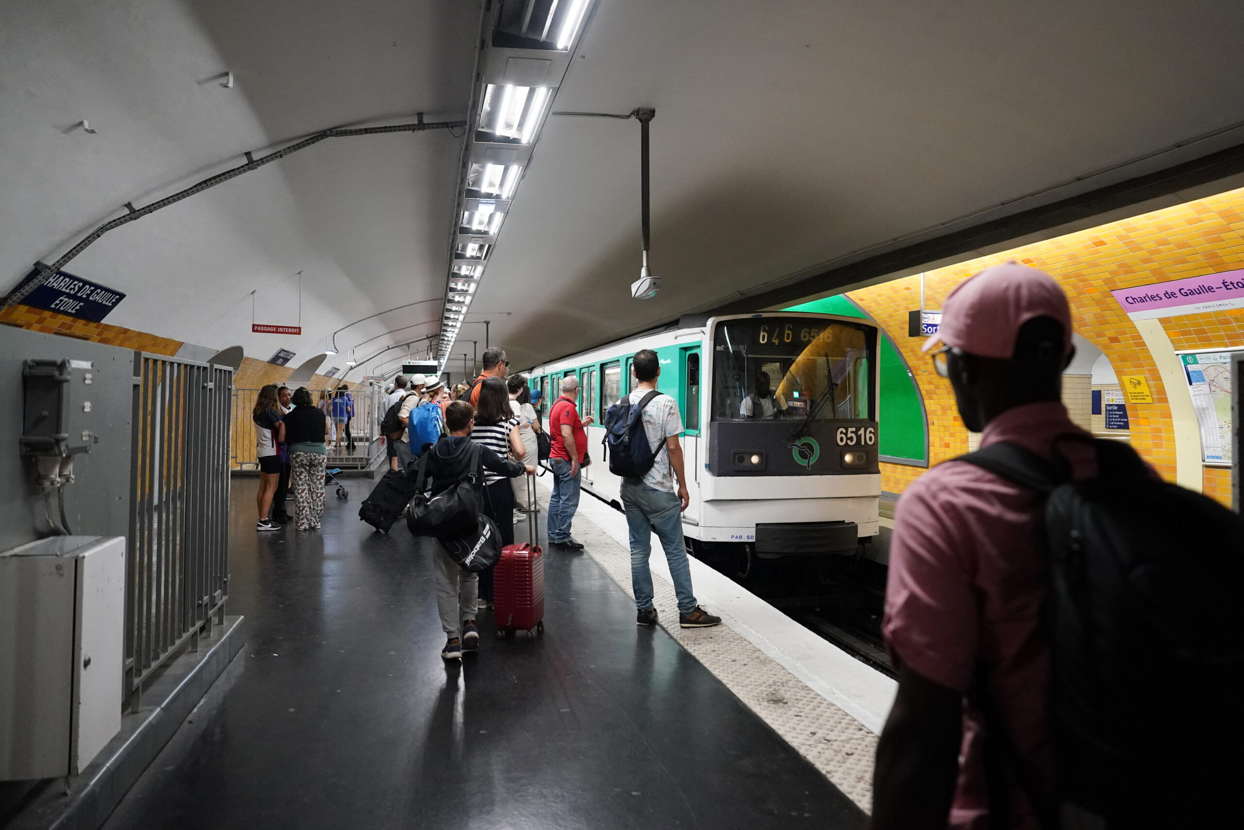 Reisende warten in einer Metro-Station auf einen Zug.