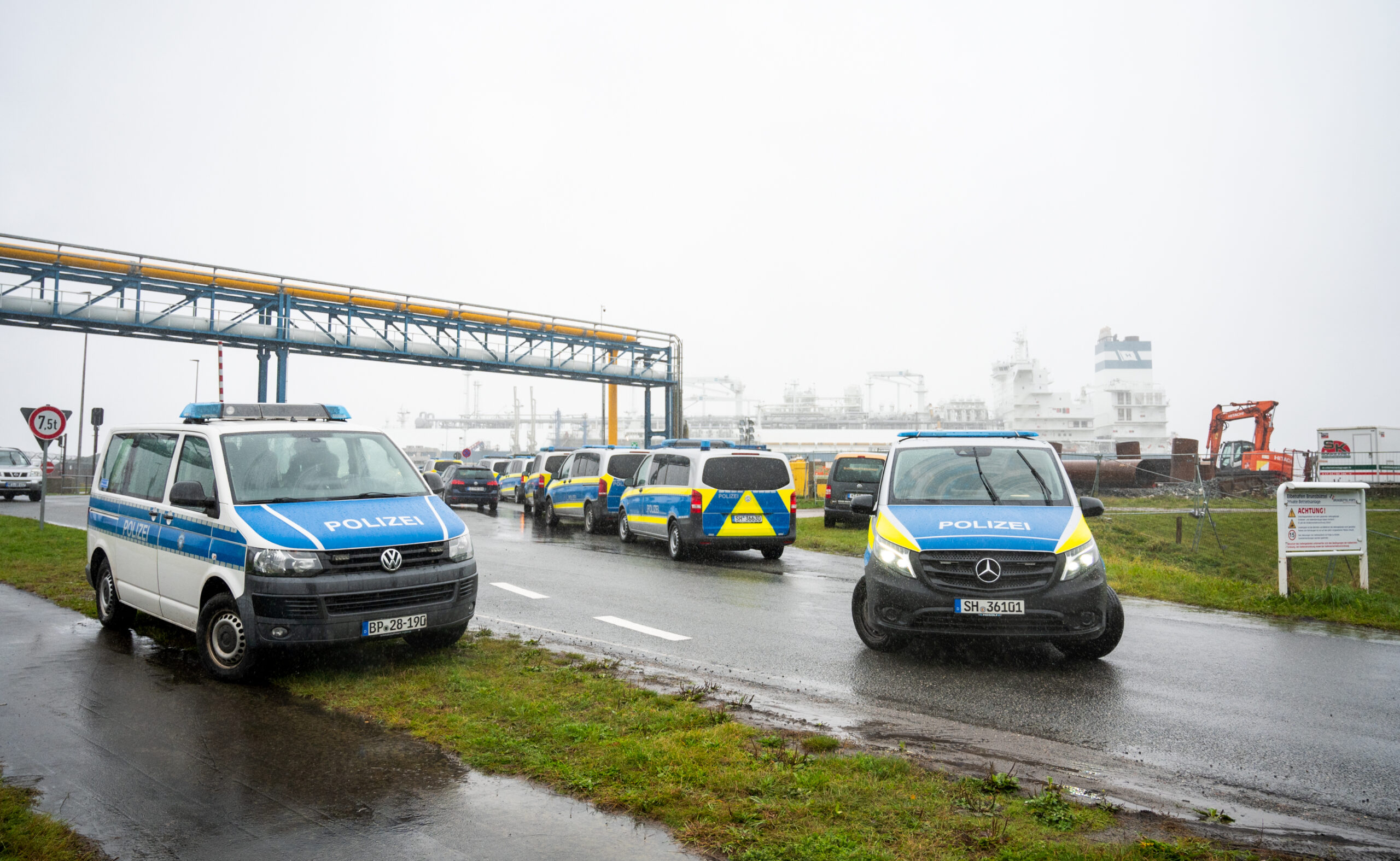 Polizeifahrzeuge stehen an einer Baustelle von einem Anleger für Flüssiggasimporte.