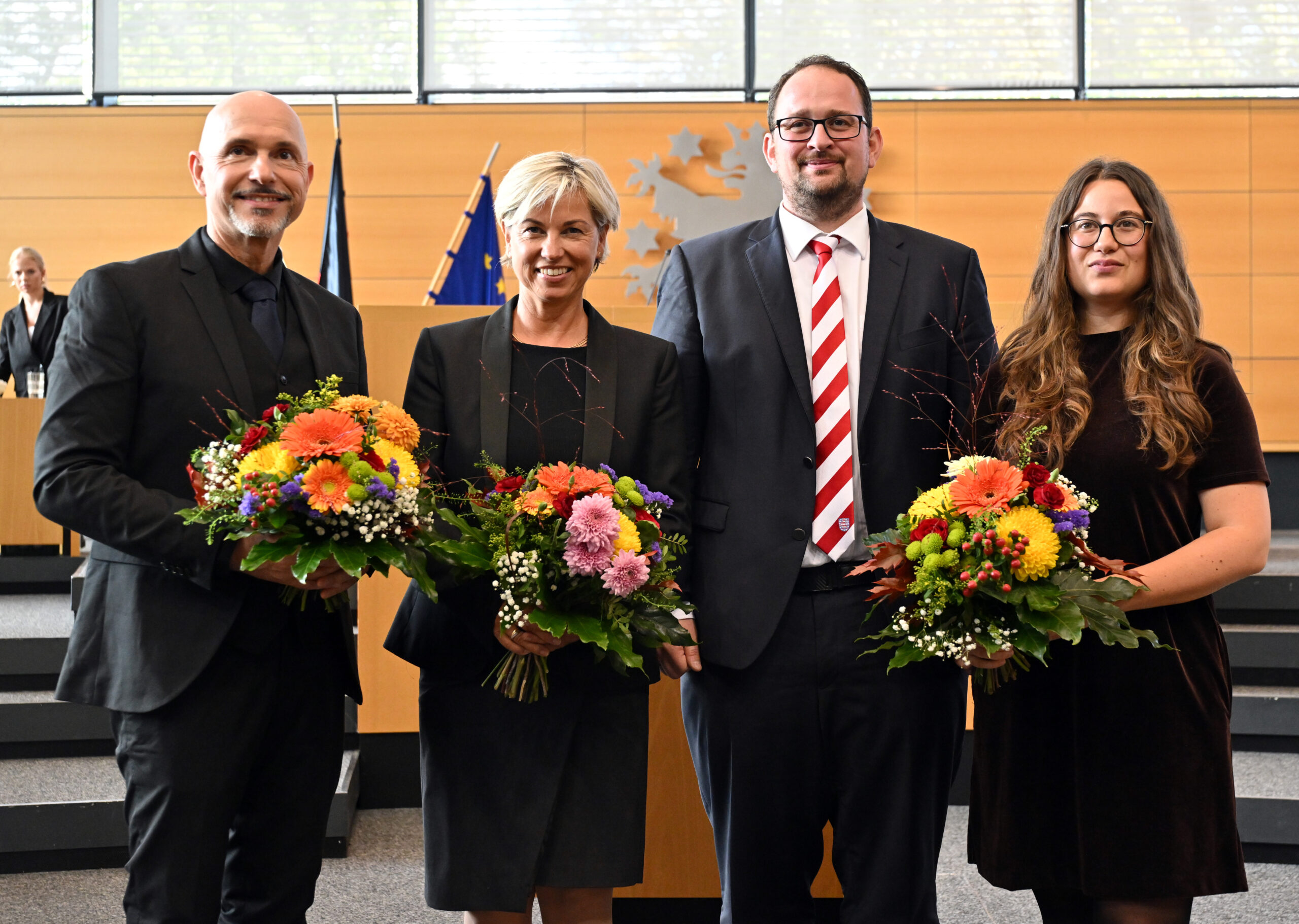 Thadäus König, Landtagspräsident, Steffen Quasebarth, Vizepräsident, Cornelia Urban, Vizepräsidentin und Lena Saniye Güngör, Vizepräsidentin, stehen im Plenarsaal während der konstituierenden Sitzung des Thüringer Landtags