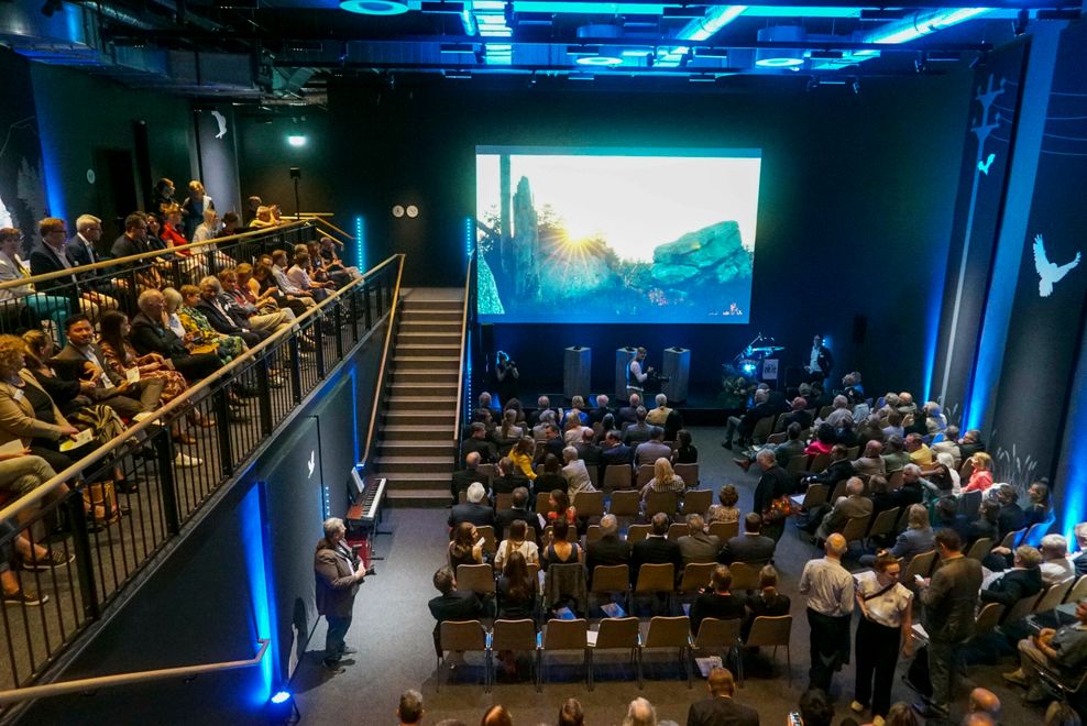 Menschen sitzen vor einer Leinwand im Naturfilmkino