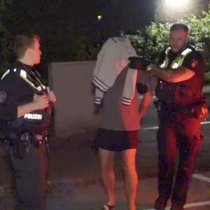 Polizisten führen den 50-Jährigen ab, der seinen Nachbarn mit einer Schreckschusspistole bedroht haben soll.