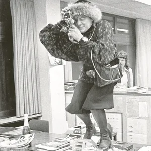 Erika Krauß steht auf einem Bürotisch, während sie ein Foto mit ihrer Kamera macht.