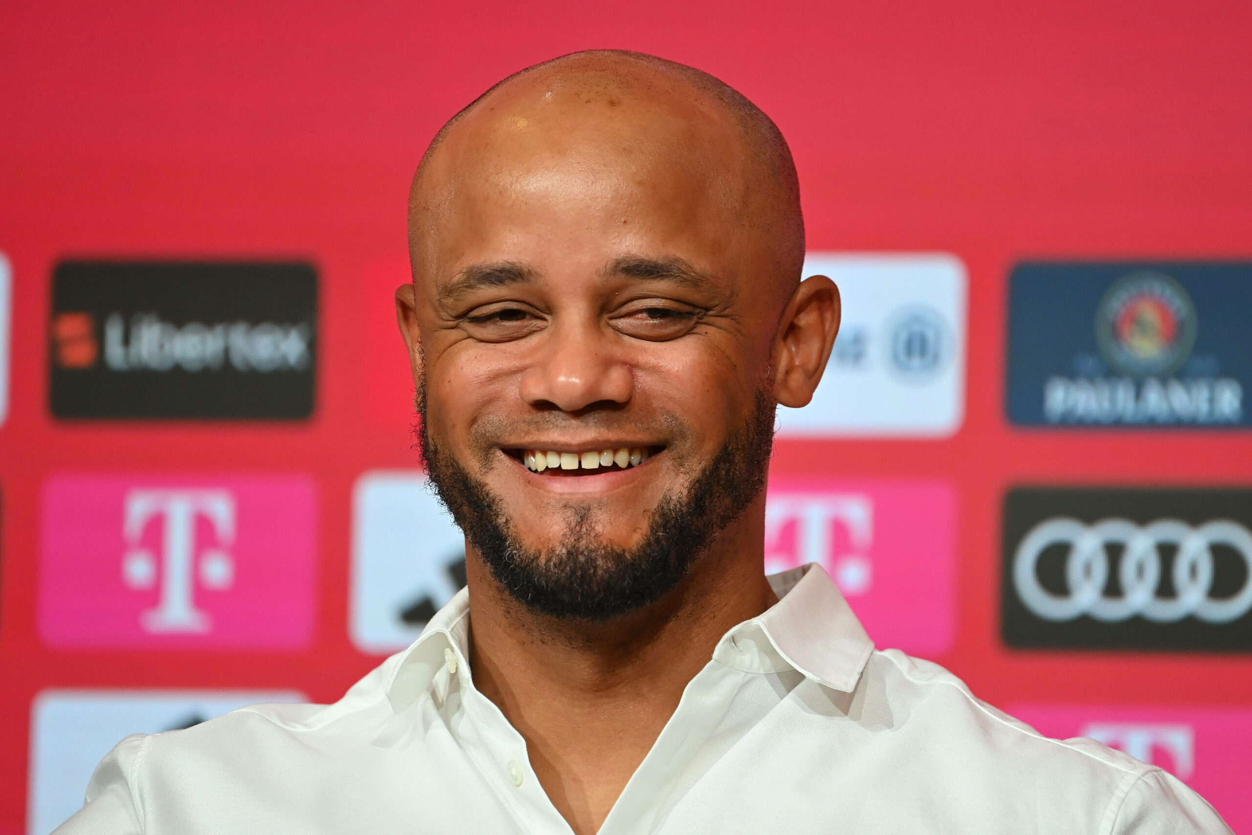 Kompany lachend auf einer Pressekonferenz