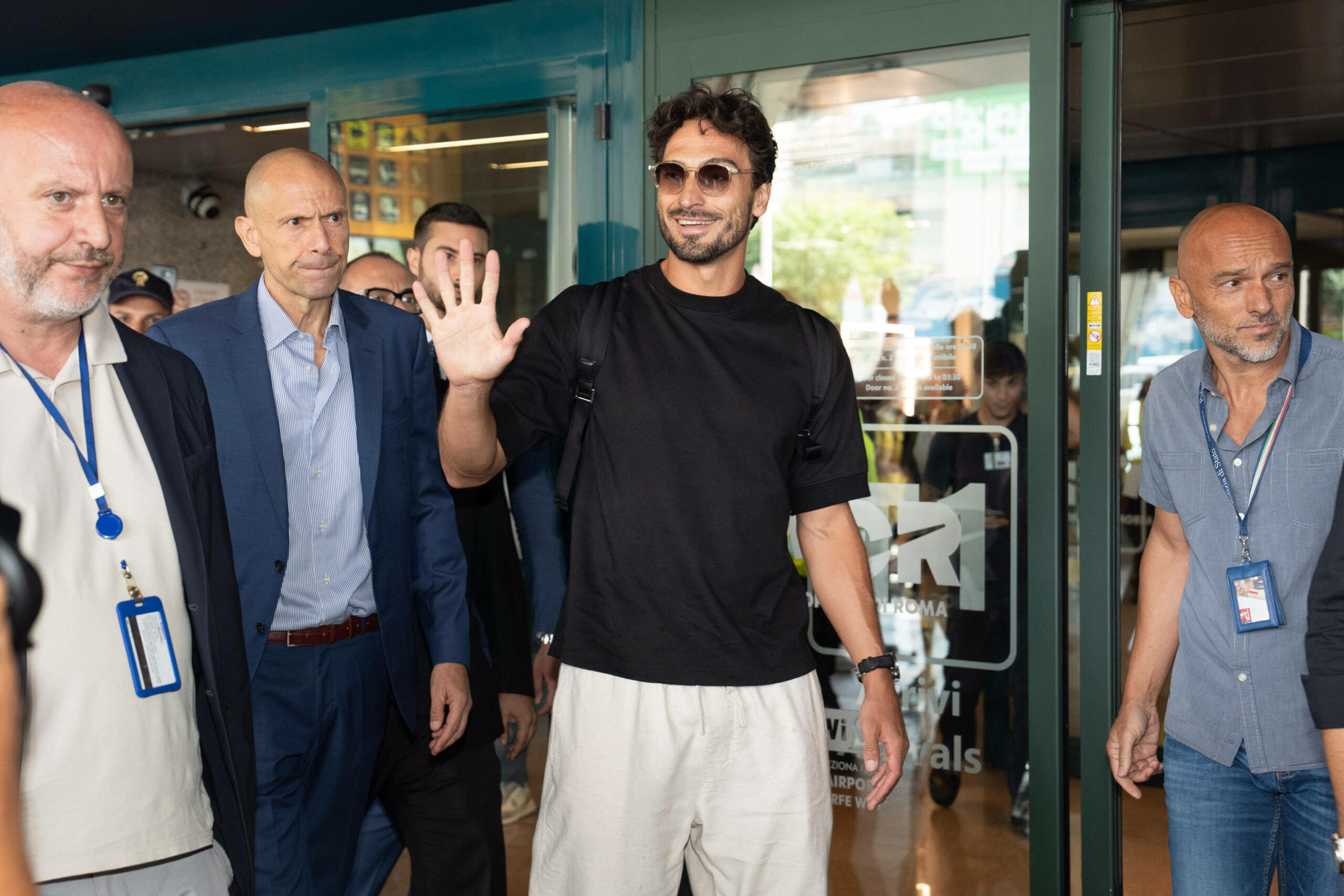 Mats Hummels kommt aus dem Flughafen raus und lächelt.