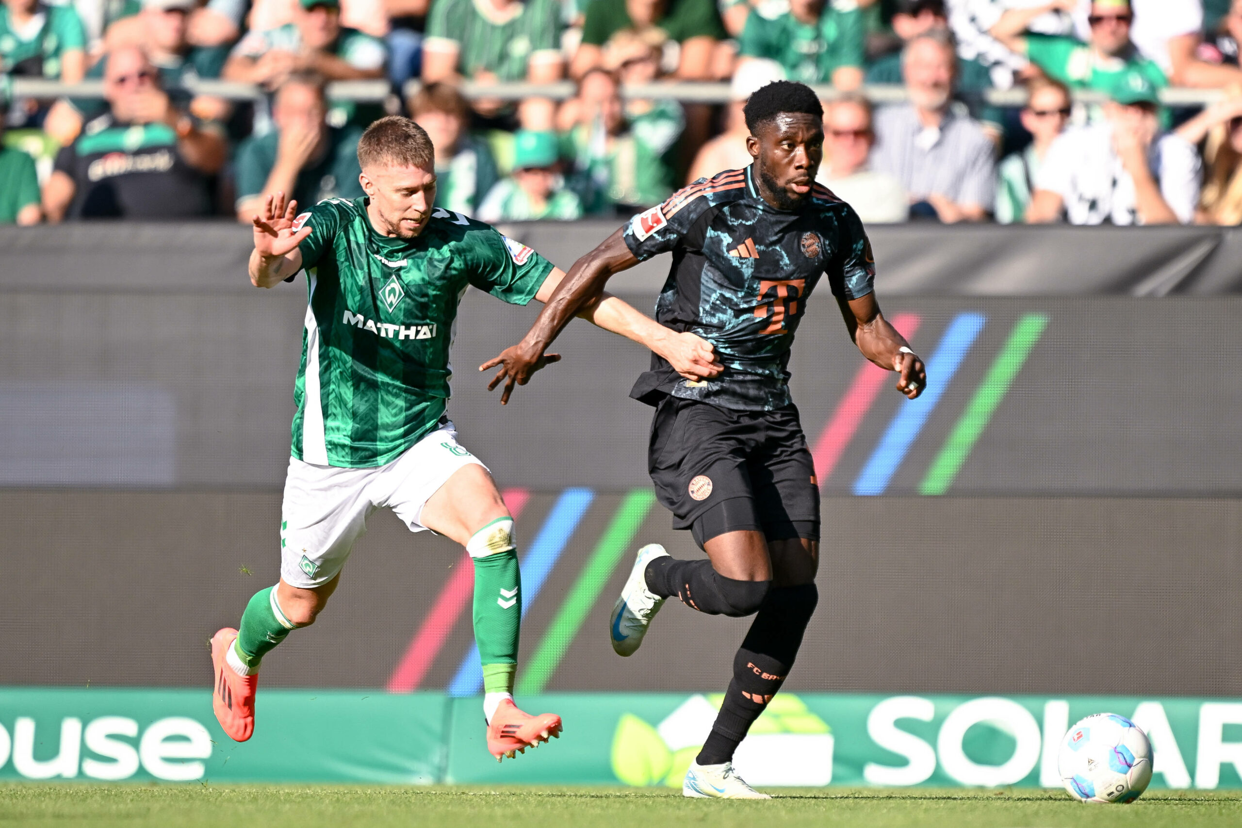 Werder-Profi Mitchell Weiser verliert einen Zweikampf gegen Bayern-Star Alphonso Davies.