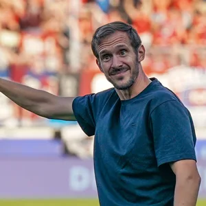Julian Schuster zeigt mit dem Finger nach oben