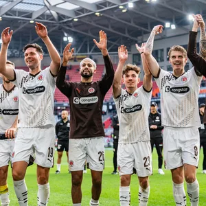 Spieler des FC St. Pauli feiern in Freiburg