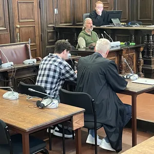 Der Angeklage Adam N. (22, l) sitzt zum Prozessbeginn neben seinem Verteidiger im Gerichtssaal.