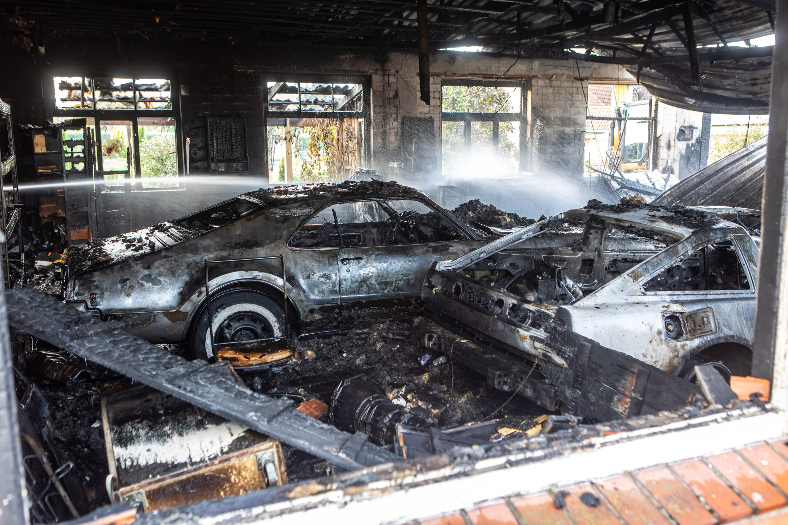 Vor Ort steht eine etwa 15x8 Meter große Halle bereits in Vollbrand. In dem Gebäude befinden sich mehrere wertvolle Oldtimer und Spezialwerkzeug.