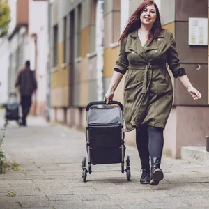 Laura Stief läuft mit ihrem Trolley in der Hand auf einem Bürgersteig.