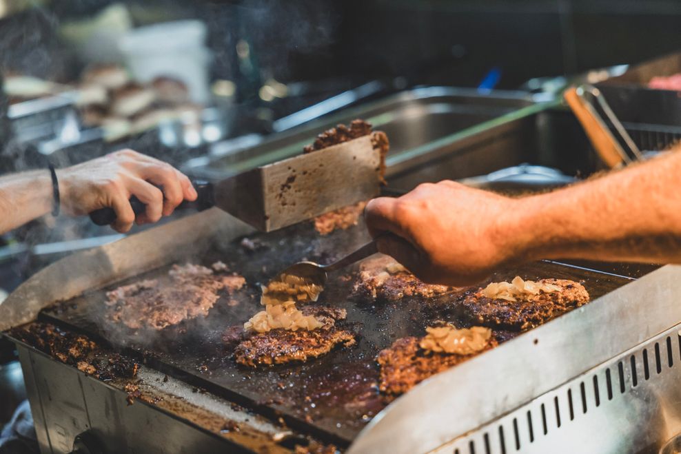 Die Patties werden zerdrückt – das sorgt für Röstaromen und Muskelkater in den Armen.