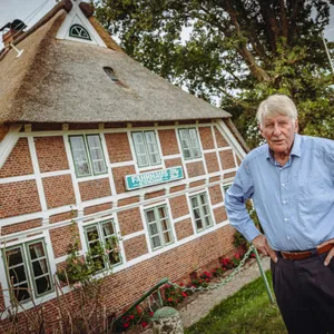 Älterer Mann vor Fachwerkhaus