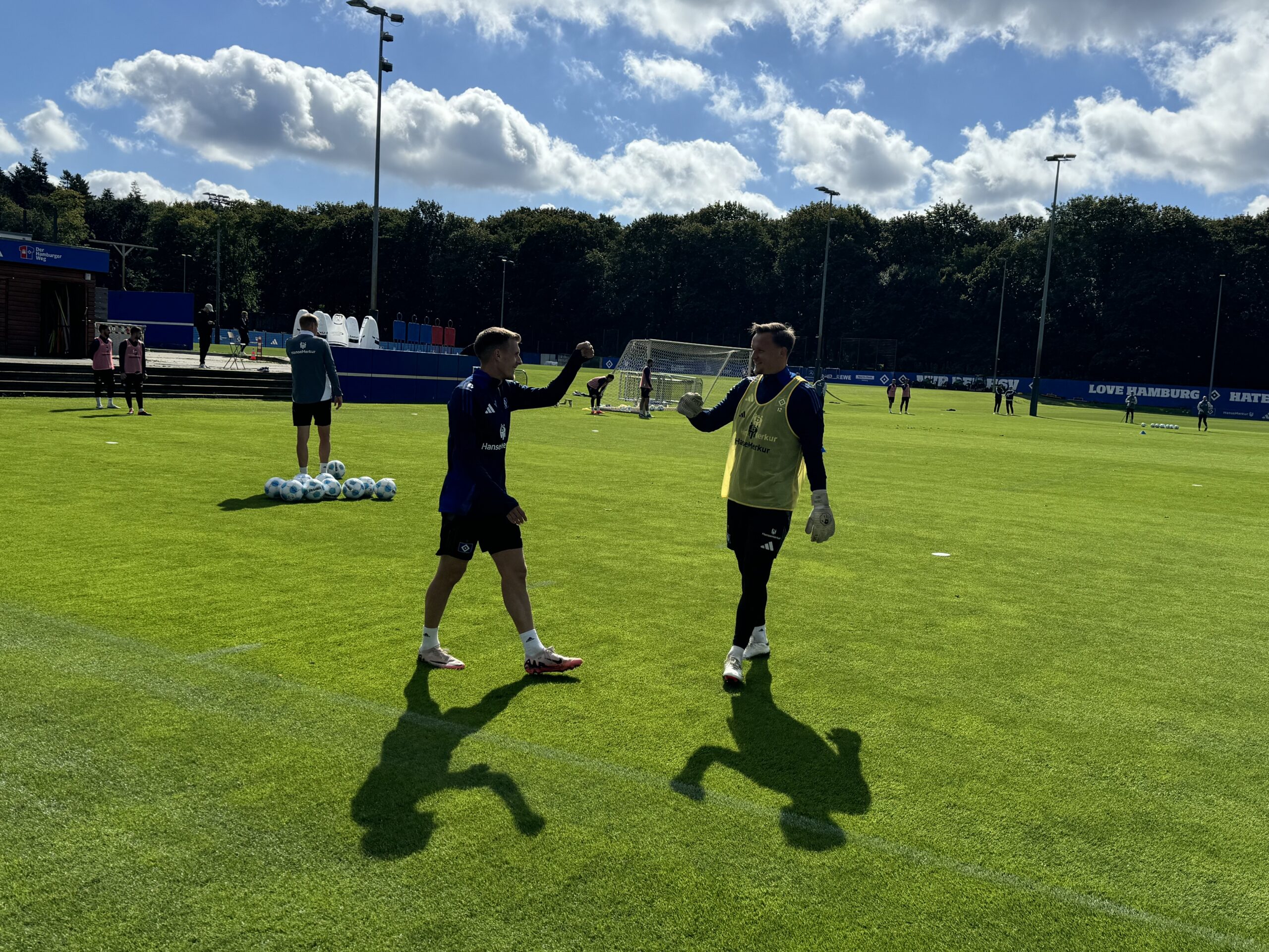 Emir Sahiti (l.) klatscht nach seinem ersten HSV-Training mit Torhüter Tom Mickel ab.