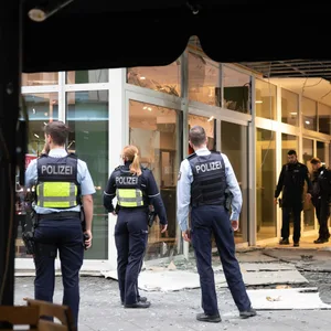 Polizeibeamte stehen am Montag nach einer Explosion vor einem beschädigten Gebäude in der Kölner Innenstadt.