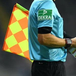 Ein Fußballschiedsrichter schreibt etwas auf