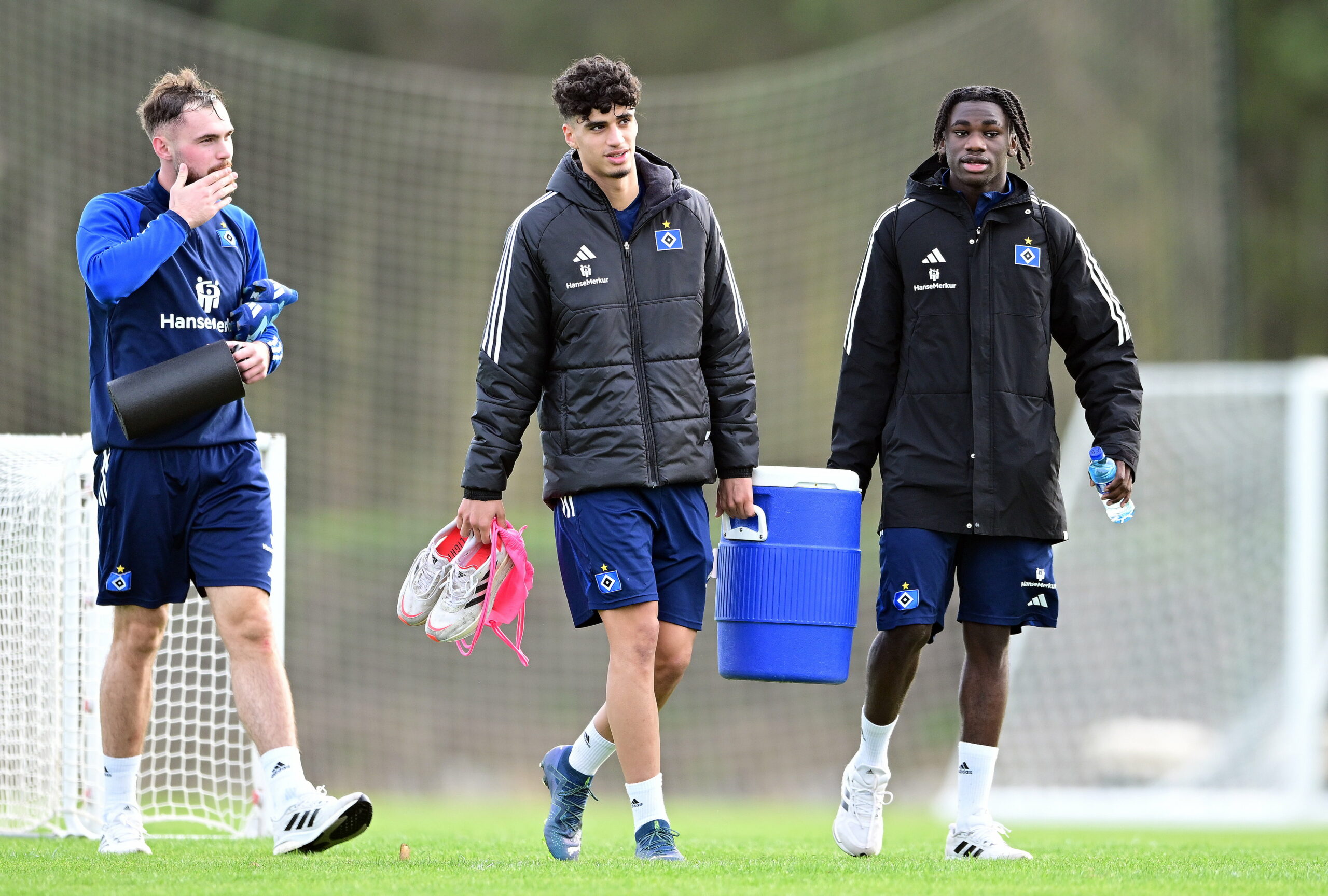 Valon Zumberi, Omar Megeed und Fabio Baldé gehen mit Materialien vom Trainingsplatz