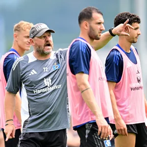 Steffen Baumgart gibt im HSV-Training neben Adam Karabec, Levin Öztunali und Daniel Elfadli Anweisungen.