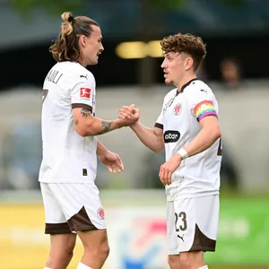 Jackson Irvine und Philipp Treu klatschen ab.