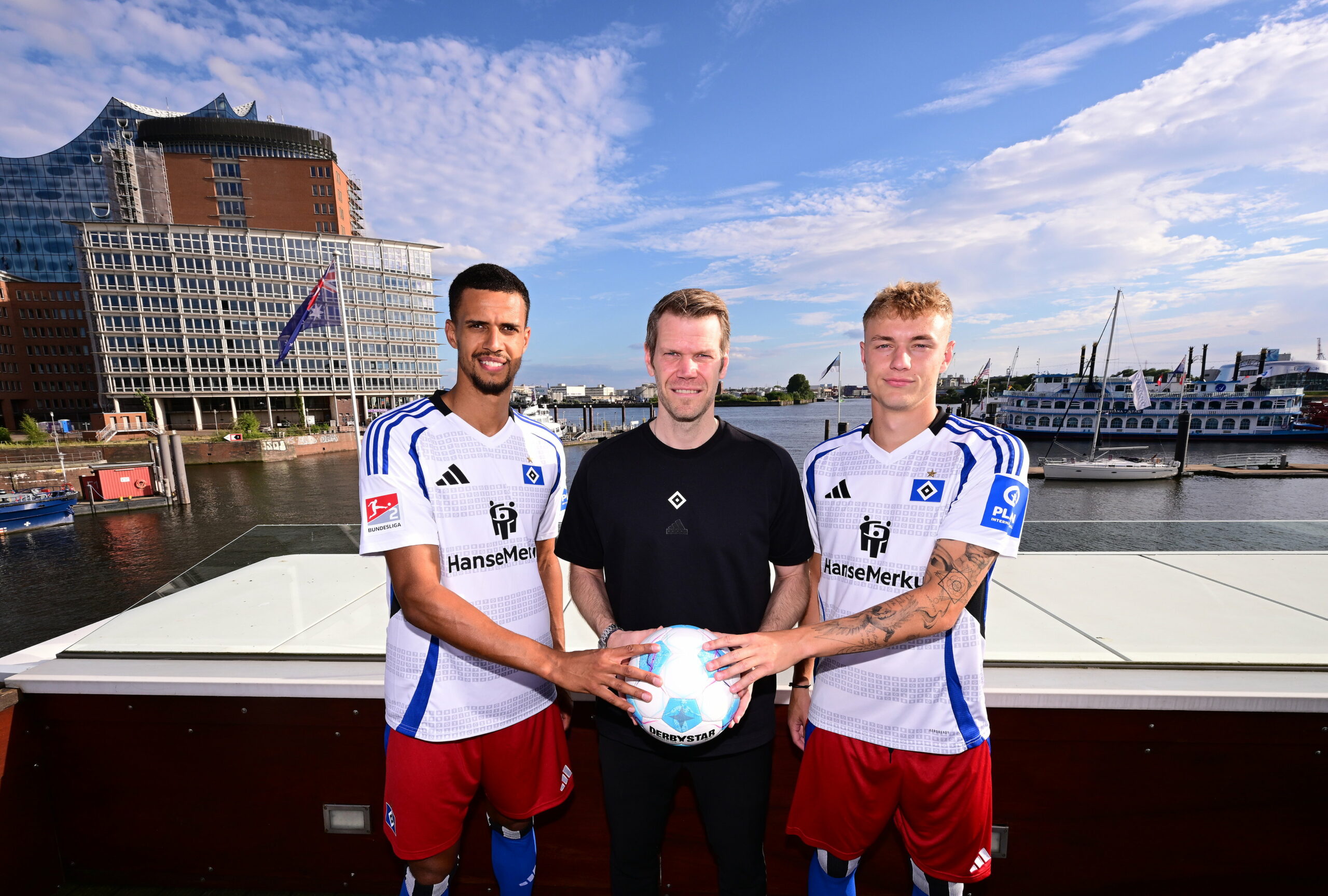 Robert Glatzel, Eric Huwer und Adam Karabec halten einen Ball und lachen in die Kamera