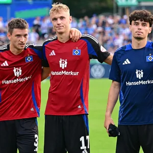 Ludovit Reis, Miro Muheim, Jonas Meffert, Robert Glatzel, Noah Katterbach, Adam Karabec und Nicolas Oliveira (v.l.) stehen Arm in Arm vor der HSV-Kurve