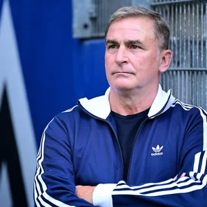 Stefan Kuntz lehnt im Innenraum des Volksparkstadions mit verschränkten Armen an einer Wand.